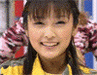 A person in a yellow shirt with a pink and white patterned garment behind them, showing slight head movement and expression change.