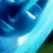 Pixelated blue-toned abstract composition with dark and light cyan gradients, bright white highlights, and a small greenish-brown section on the right edge.