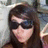 A pixelated image of a person with long dark hair and sunglasses on a bright pink background with text overlays.