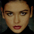 Pixelated image of a person with dark hair and red lips on left, green background with bright green text 'Original Icons .com' on right.