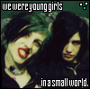 Two people with dark hair and green-tinted hair strands pose closely together under text reading "we were young girls" and "in a small world."