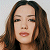 Static pixelated image of a person with long brown hair and closed eyes against light background