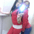 A person in a red top and blue pants holds a camera with a bright flash, positioned against a light background.