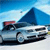 Pixelated image of a silver sedan with a blue roof against a blue sky background, showing partial red and black elements on the left side.