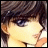 Anime-style character face with brown hair and blue eyes, next to pixelated text on black background.