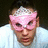 A person wearing a pink mask with white accents appears on the left side of a black background, accompanied by pixelated text reading "the coolest person" and "you'll evr meet is my brother! snt he cute".