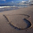 Beach scene with sand drawing of a heart and the word 'love' in green text.