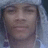 Pixelated close-up of a person's face with closed eyes, neutral expression, and light skin tone against a blurred background.