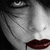 A black-and-white close-up of a person's face with dark hair, red lips, and a single drop of blood dripping from the mouth, accompanied by repeated 'FMS' text elements.