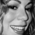 Black-and-white pixelated close-up of a person's face showing eyes, nose, mouth, and hair with visible teeth in a smile.