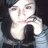 Pixelated image of a person with light skin tone holding an object near their face, wearing dark clothing against a gradient background.