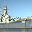 Static pixelated image of a military ship on water under blue sky with visible compression artifacts and dithering.