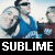 Pixelated static image of a person in blue clothing with motion blur effects and bold white text reading "SUBLIME" on a black bar at the bottom.