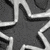 A grayscale star-shaped icon with sharp points and a central dark core, surrounded by lighter gray and white pixelated patterns on a dark background.