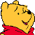 Pixelated yellow cartoon bear head with red shirt, black nose, and smiling expression on gray background.