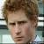 Static pixelated image of a person with light brown curly hair, neutral expression, and visible ear against blurred background.