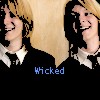 Two side-by-side pixelated figures with blonde hair and black-and-white collared shirts, one smiling left, the other right, with blue text below reading 'Wicked'.