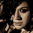 Pixelated close-up of a person's face with dark hair against black background, rendered in low-resolution 48x48 pixels using brown and beige tones.