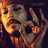Pixelated image of a person with long hair and beard holding a skull, accompanied by pixelated text on black backgrounds.