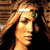 Pixelated static image of a person with light brown hair and closed eyes, wearing a white headband and green eyewear against a dark background.