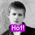 A grayscale pixelated portrait of a person with short dark hair wearing a black jacket over a white shirt, overlaid by a bright purple rectangular text box containing "Hot!" in white letters.
