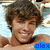 A shirtless person with curly brown hair smiles in a pool, with text overlays changing across frames.