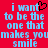 Red background with light blue pixelated text reading "i want to be the one that makes you smile" and a black heart symbol replacing the 'o' in 'want'.