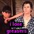 A pixelated image shows a person in a sleeveless top holding an object, with purple text reading "i love greasers" overlaid on black bars.
