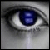 Pixelated close-up of a human eye with dark eyeliner, featuring a blue iris containing two white square shapes.