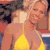 Pixelated static image of two people in a close embrace, one wearing a yellow bikini top and the other with light-colored hair, set against an indistinct background.
