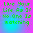 Green pixelated text reads "Live Your Life As If No One Is Watching" on a gradient background shifting between pink and cyan hues.