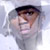 Pixelated static icon of a person with dark hair and light skin wearing a white hooded garment, partially obscured by pixelation artifacts.