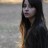A pixelated static image shows a person with long dark hair against a blurred background of light and muted tones.
