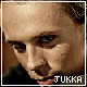 Pixelated close-up of a person's face with dark hair, showing two slightly different expressions and text reading JUKKA at the bottom.