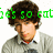 A pixelated image of a person with brown curly hair wearing a light gray sweater over a white collared shirt, with green text partially visible above the head.
