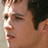 A pixelated image of a person's face with short dark hair, partially visible against a teal and gray background. Below the face is bold white text reading "THE CHUM SCRUBBER" on a black strip.