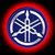 Circular icon with blue and white stylized design on red gradient background, surrounded by black border.
