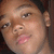 Pixelated close-up of a person's face with light skin tone, dark hair visible at top right, and pink lips slightly parted.