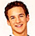 Pixelated static image of a smiling man with short dark hair and light skin, wearing a white shirt against a plain background.