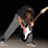 A person with long brown hair plays a white electric guitar against a black background, captured in three sequential poses showing dynamic movement.