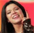 A pixelated close-up of a person with long dark hair, wearing a dark top, against a bright red background with a yellow vertical stripe on the left.