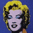 Four pixelated of a woman's face with blonde hair, each on distinct solid backgrounds in blue, pink, green, and light blue