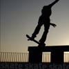 Silhouette of a person performing a skateboard trick on a rail against a gradient sky background with repeated 'skate' text at the bottom.