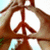 Brown peace symbol with white circular background and light blue sky-like backdrop, rendered in pixelated style.