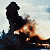 A pixelated static image shows a dark silhouette of a figure holding a burning object against a light sky background.