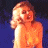 A pixelated vintage-style buddy icon featuring a blonde woman in an orange swimsuit on the left and green text reading "Original Icons .com" on the right against a dark blue background.