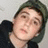 A static image with a yellow background, featuring a person in a dark hoodie and green cap on the left, and pink text reading "I LOVE YOU." and "maybe you dont know it yet." with four heart symbols on the right.