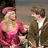 A pixelated image of two people in period clothing against a bright pink background with overlaid text.