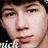Pixelated close-up of a person's face with dark hair, visible eyes, nose, mouth, and partial neck against a dark background.