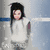 A static image of a person in white clothing against a light blue background with subtle horizontal lines.
